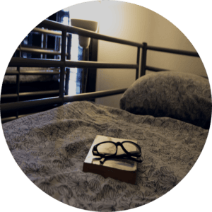 book and glasses on bed