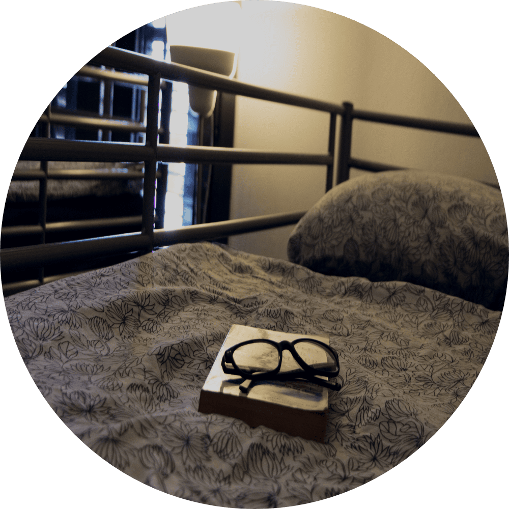 book and glasses on bed