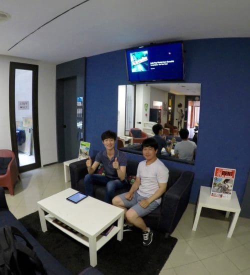 two men sitting on the couch at hostel in barcelona