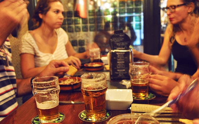 friends drinking beer and eating tapas